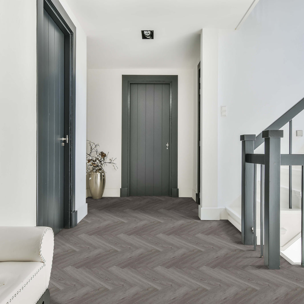 Modern interior hallway with gray flooring, white walls, and a staircase.