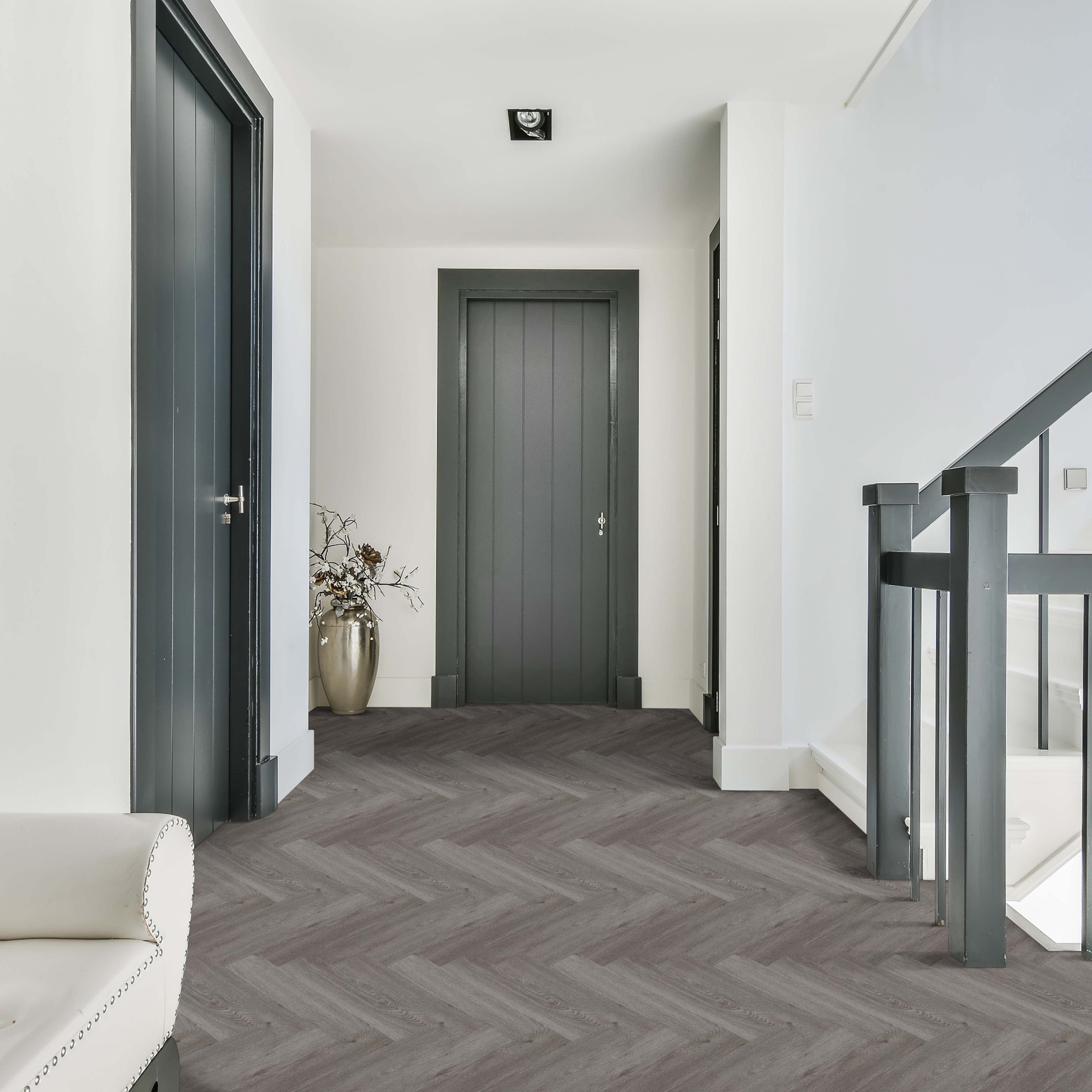 Modern interior hallway with gray flooring, white walls, and a staircase.