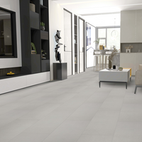 Modern living room with gray tiles, furniture, and decor.